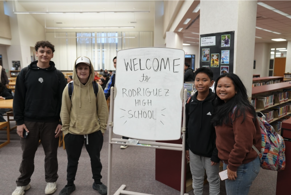 Kids taking a picture in front of a welcome sign