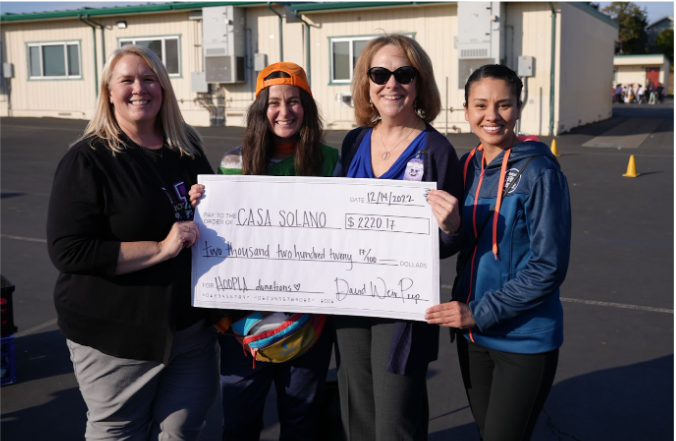 Staff holding a giant check